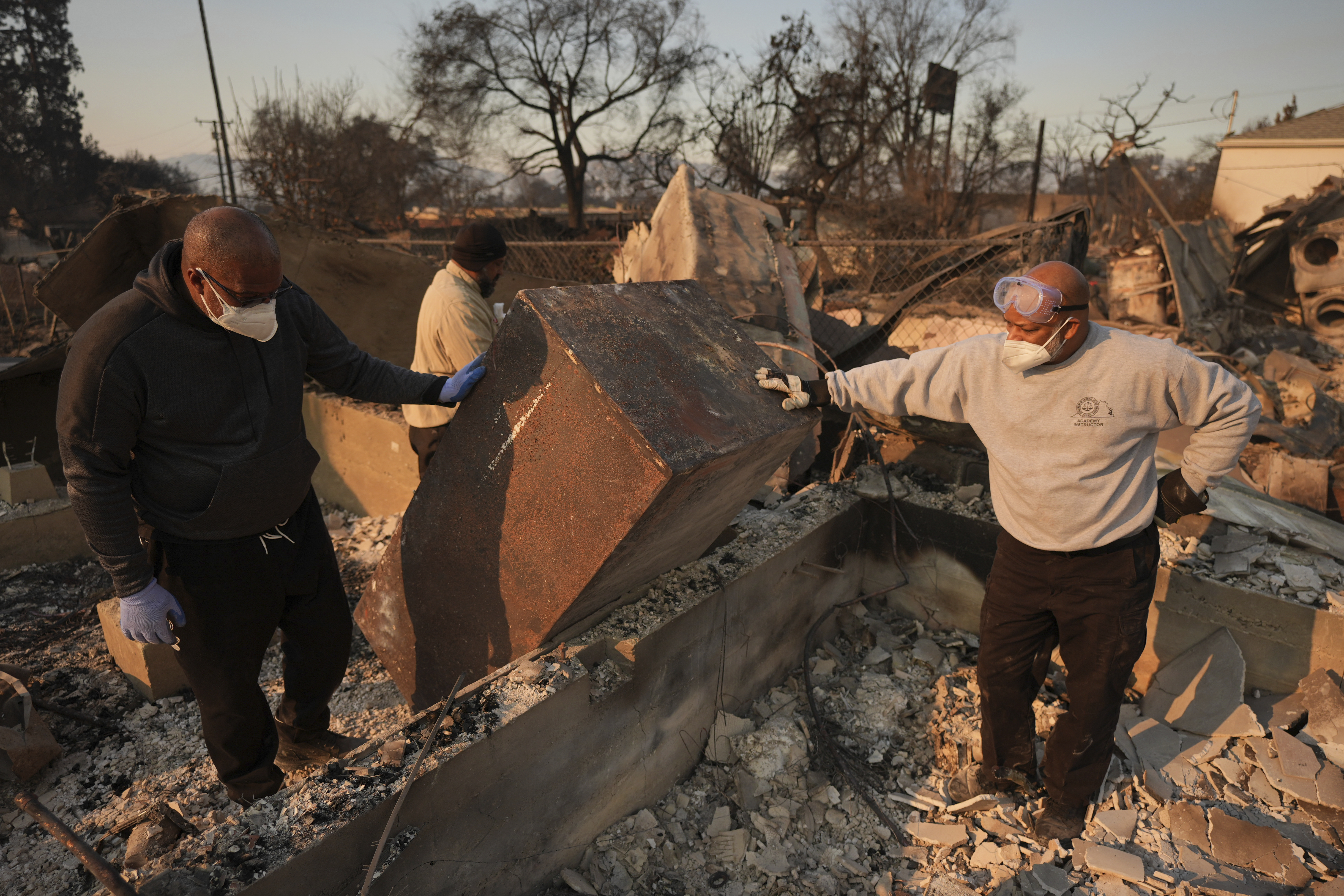 Kenneth Snowden, left, surveys the damage to his fire-ravaged property with his brother Kim, center, and Ronnie in the aftermath of the Eaton Fire Friday, Jan. 10, 2025 in Altadena, Calif. (AP Photo/Jae C. Hong)