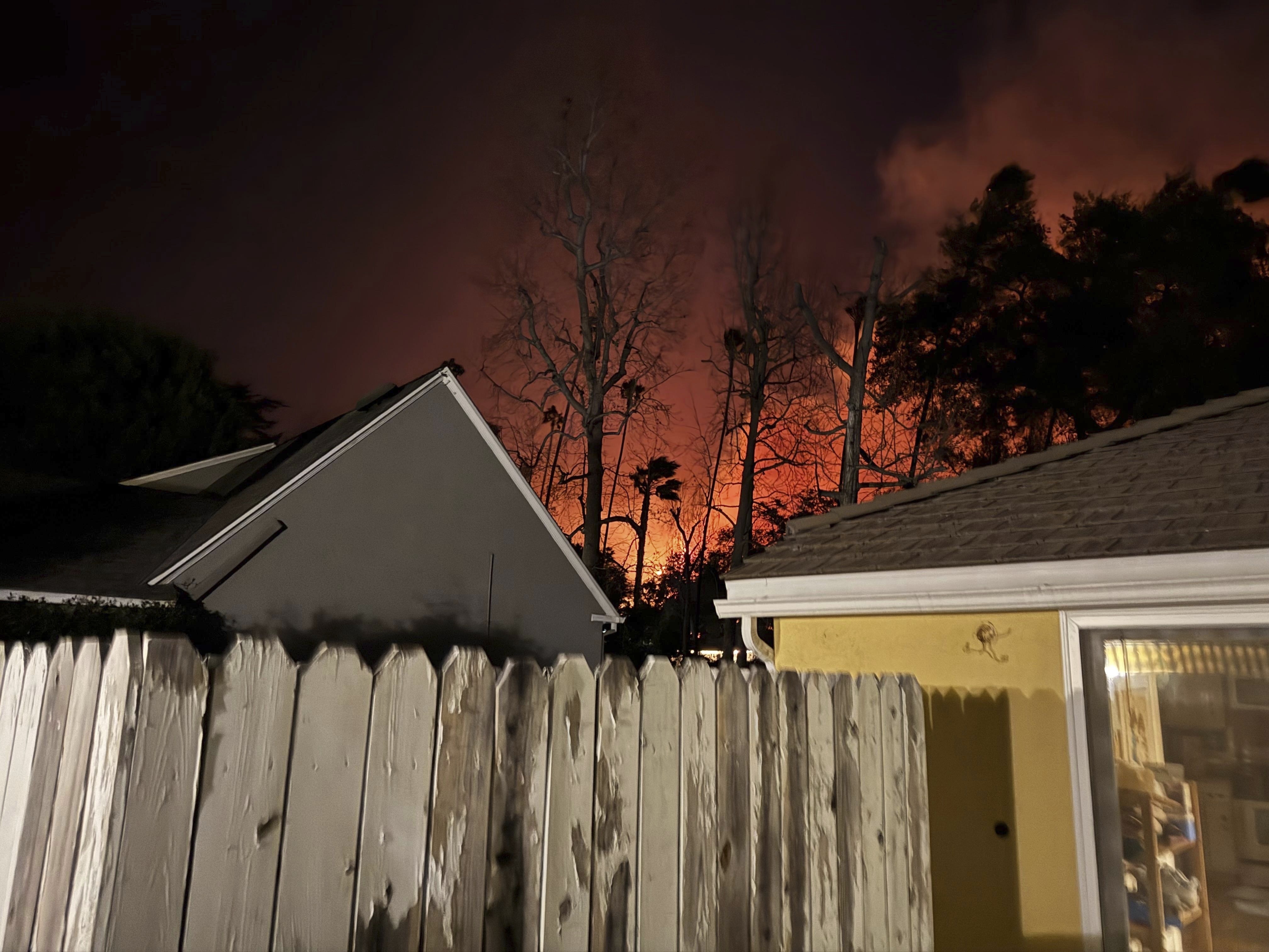 The Eaton wildfire approaches the yellow home of the Prata family in Altadena, California, the night of Tuesday, Jan. 7, 2025. (AP Photo/Vanessa Prata)