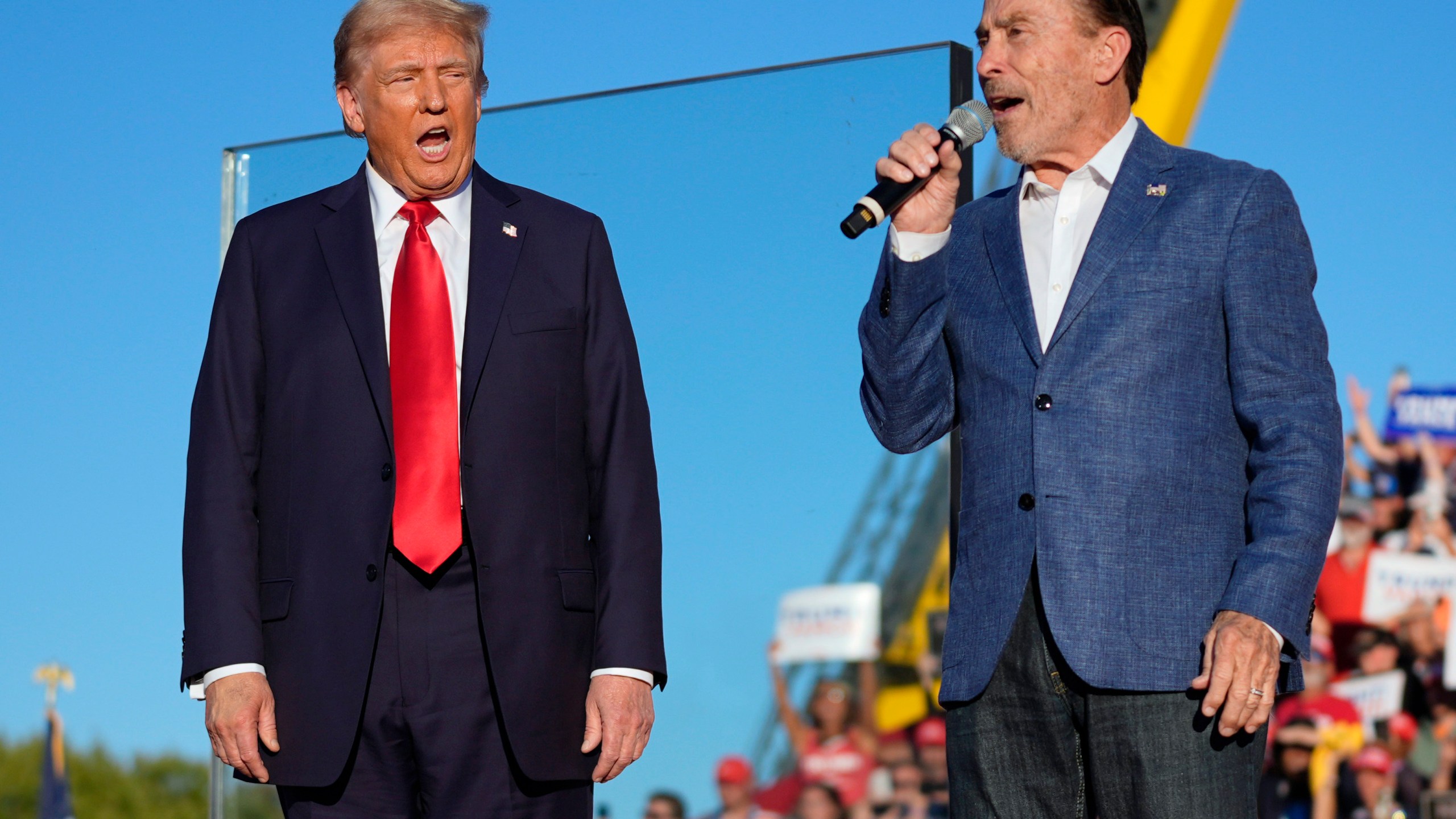 FILE - Republican presidential nominee former President Donald Trump, left, listens to Lee Greenwood at a campaign rally, Oct. 5, 2024, in Butler, Pa. (AP Photo/Evan Vucci, File)