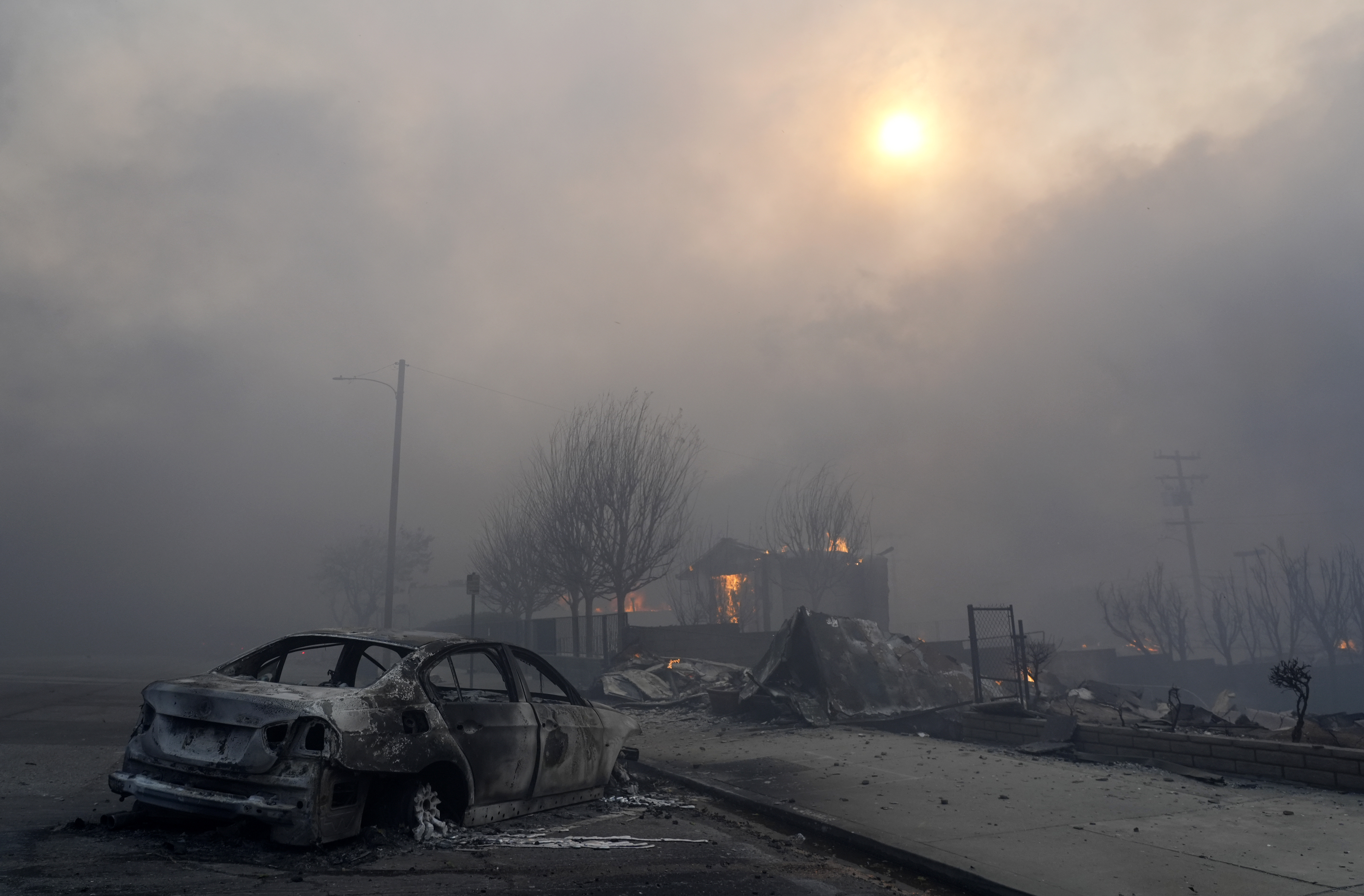 FILE - A burned-out car sits among rubble in the downtown Altadena section of Pasadena, Calif., Jan. 8, 2025. (AP Photo/Chris Pizzello, File)