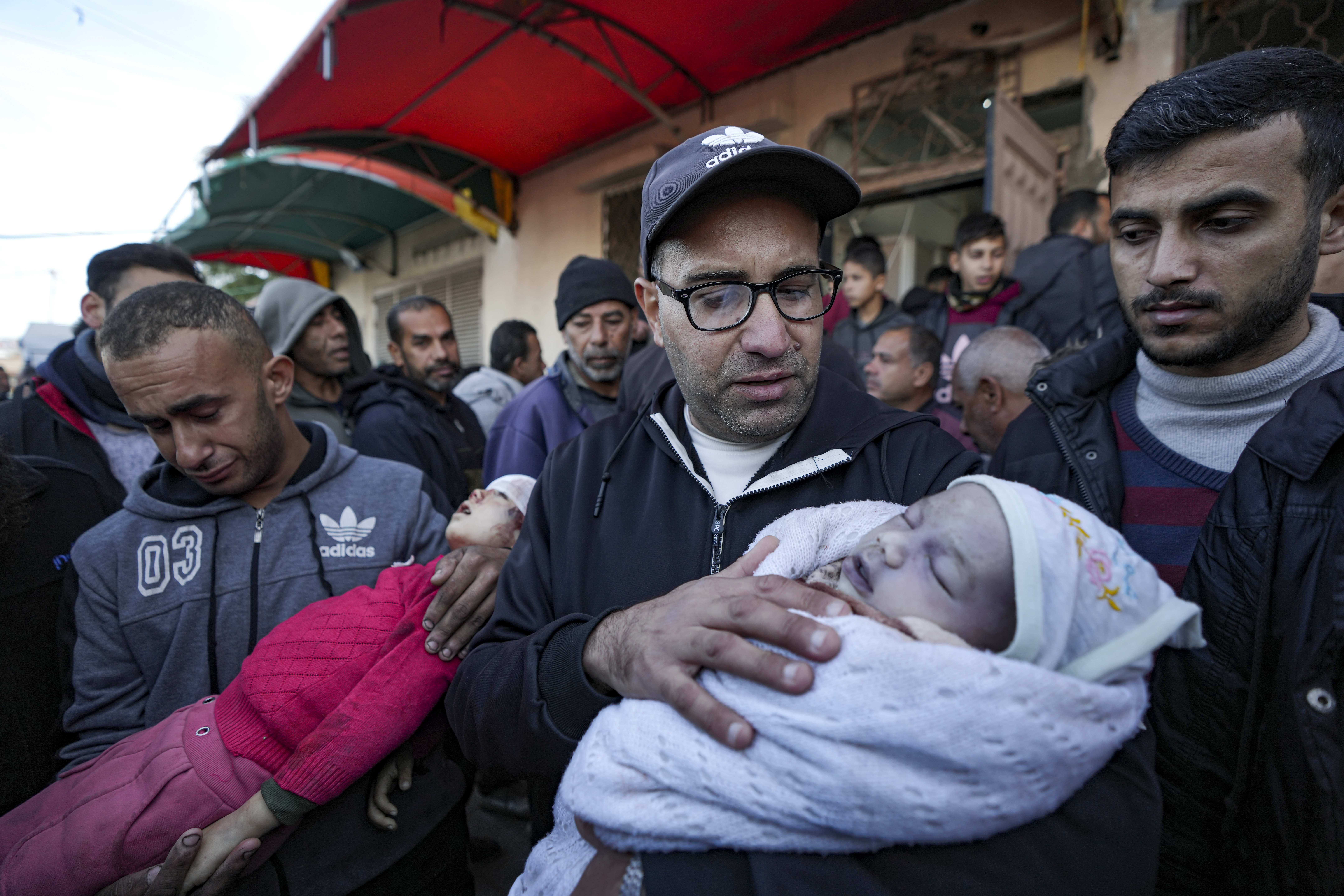 EDS NOTE: GRAPHIC CONTENT - Relatives react as they carry the bodies of children who were killed by an Israeli airstrike on the Gaza Strip at the Al-Aqsa Hospital in Deir al-Balah, Tuesday, Jan. 14, 2025. (AP Photo/Abdel Kareem Hana)