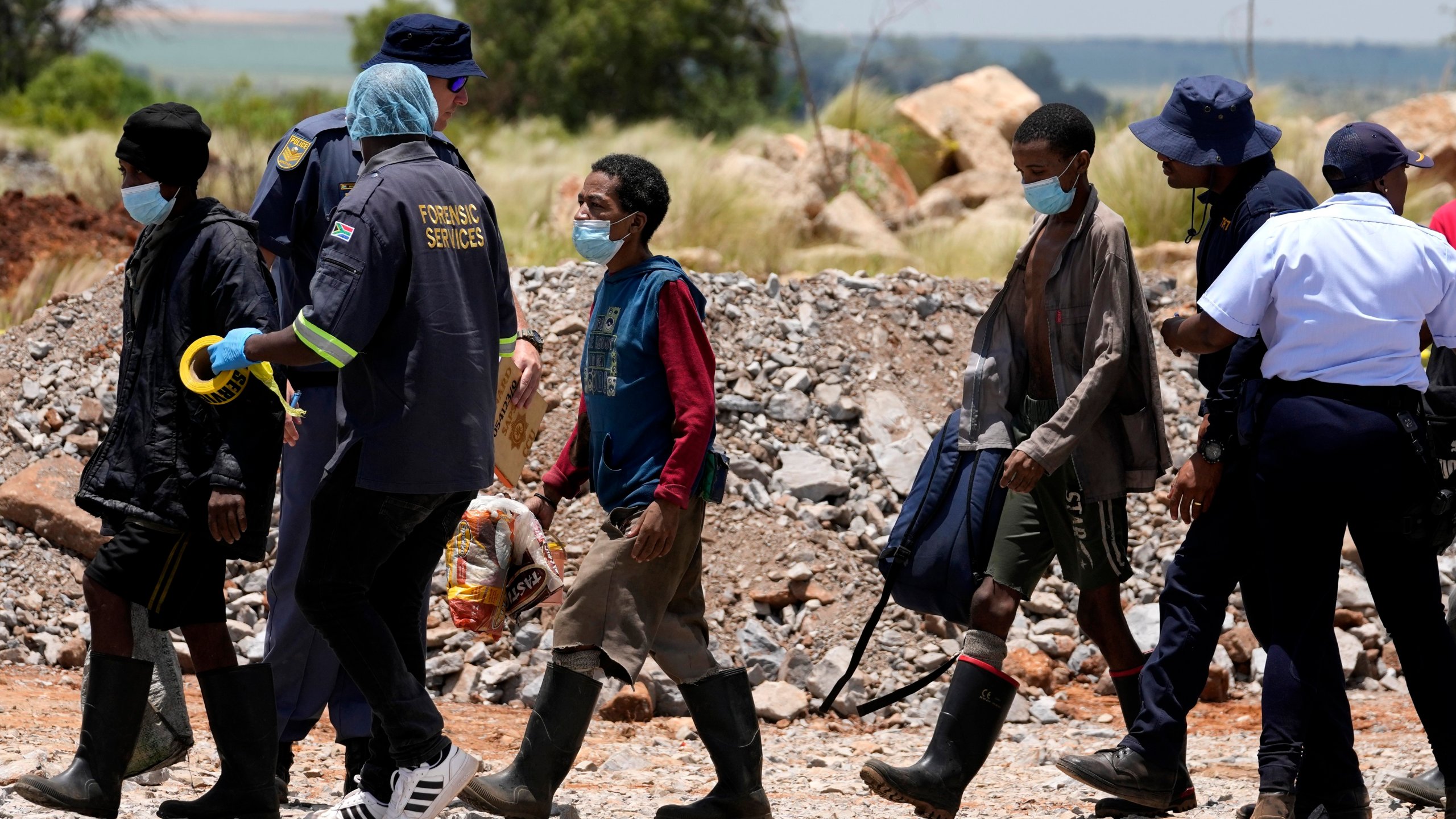 Illegal miners are escorted by police officers after being rescued from an abandoned gold mine for months, in Stilfontein, South Africa, Tuesday, Jan. 14, 2025. (AP Photo/Themba Hadebe)