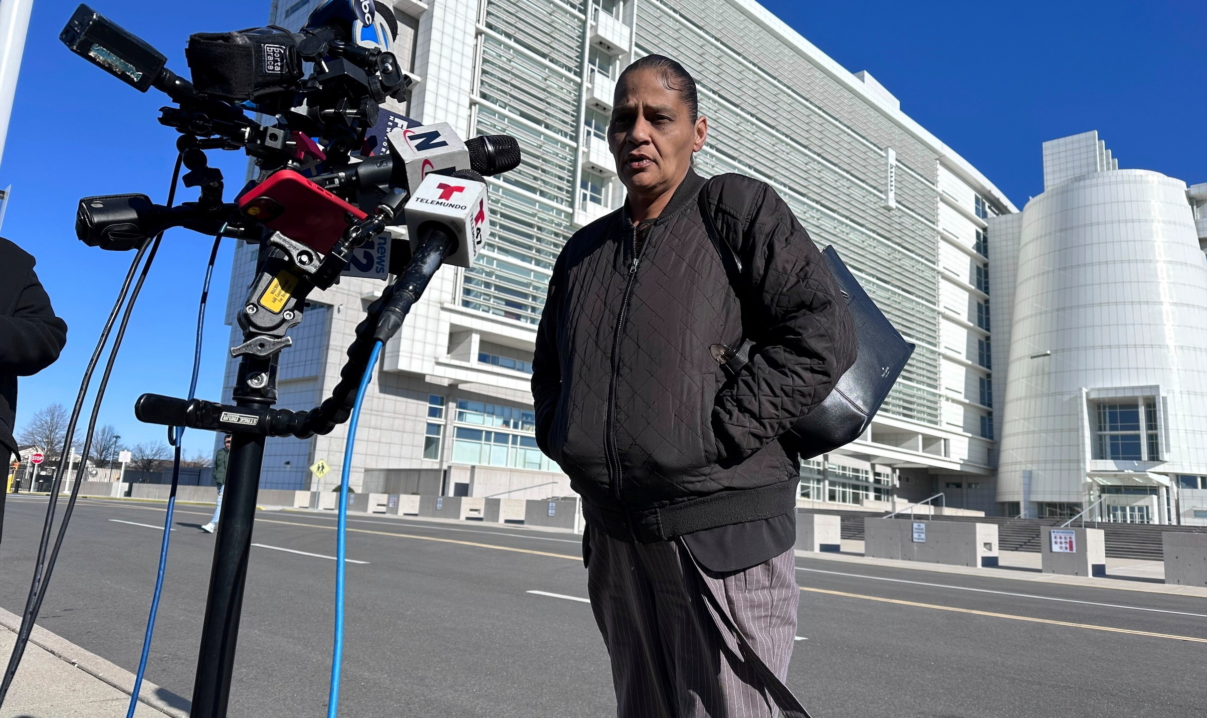 Elizabeth Alvarado, the mother of Nisa Mickens, a 15-year-old who was killed by MS-13 gang members in 2016, speaks outside the federal court, behind, in Central Islip, New York, where Jairo Saenz, a high-ranking member of a local MS-13 clique, pleaded guilty to racketeering and other federal charges on Tuesday, Jan. 14, 2025. (AP Photo/Philip Marcelo)