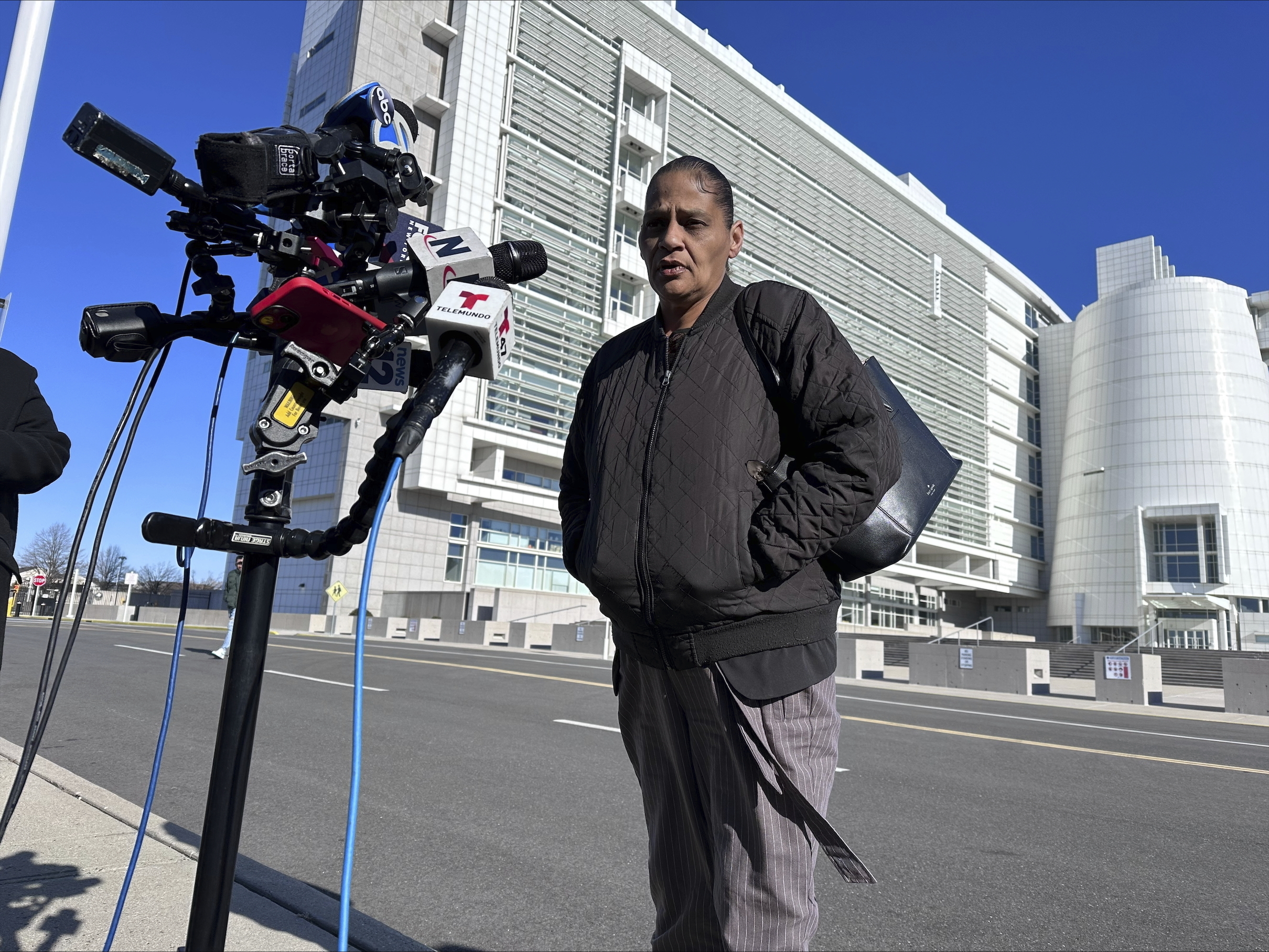 Elizabeth Alvarado, the mother of Nisa Mickens, a 15-year-old who was killed by MS-13 gang members in 2016, speaks outside the federal court, behind, in Central Islip, New York, where Jairo Saenz, a high-ranking member of a local MS-13 clique, pleaded guilty to racketeering and other federal charges on Tuesday, Jan. 14, 2025. (AP Photo/Philip Marcelo)