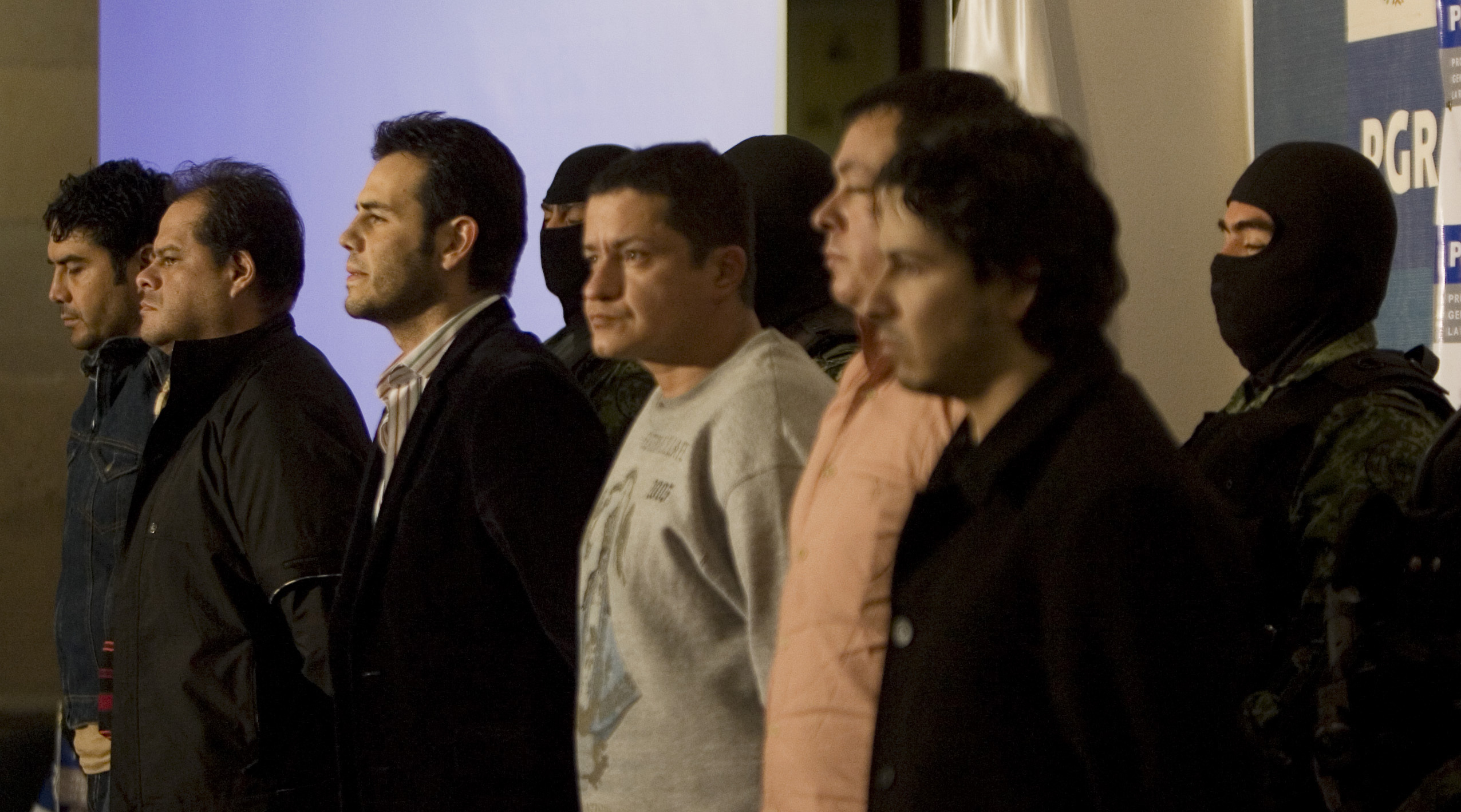 FILE - Military officers guard alleged drug trafficker Vicente Zambada, third left front, and five unidentified men who were presented to the press as Zambada's alleged bodyguards in Mexico City, March 19, 2009. Vicente Zambada is the son of Mexican drug lord Ismael Zambada, head of the Sinaloa cartel. (AP Photo/Eduardo Verdugo, File)