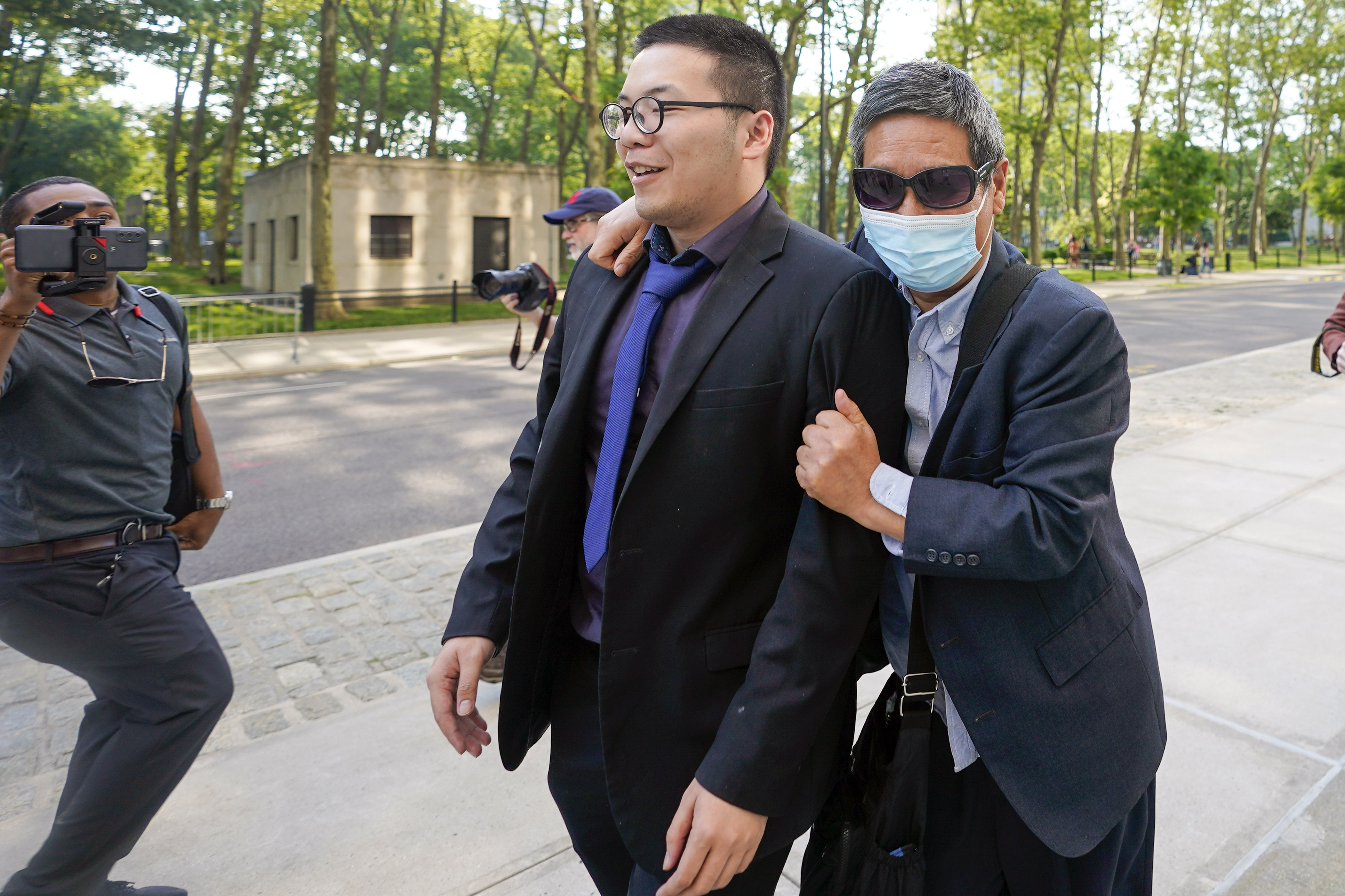 FILE - Zhu Yong, right, tries to shield himself from photographers as he leaves federal court, May 31, 2023, in the Brooklyn borough of New York. (AP Photo/Mary Altaffer, File)