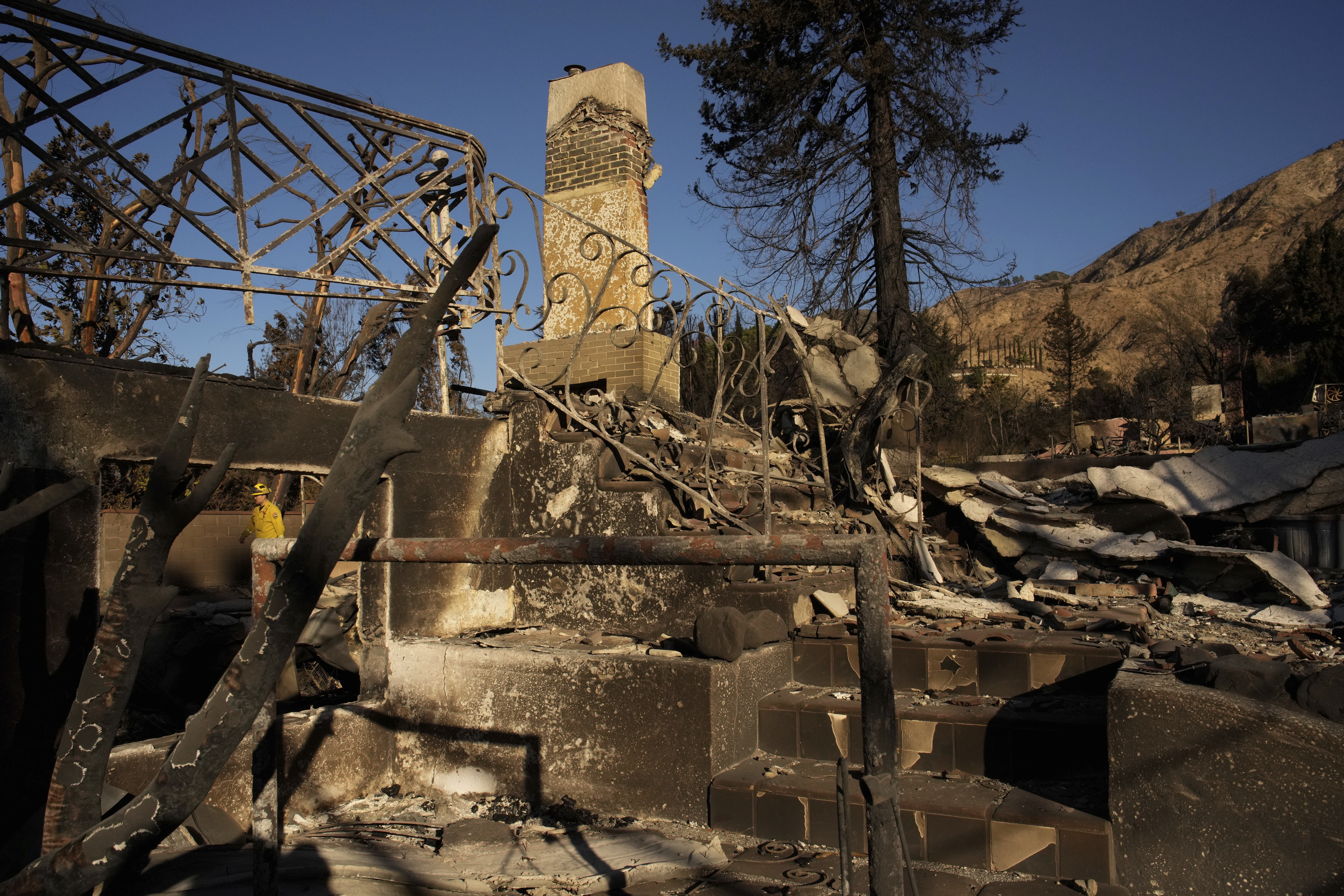 A firefighter inspects homes destroyed by the Eaton Fire in in Altadena, Calif., is seen Wednesday, Jan 15, 2025. (AP Photo/John Locher)