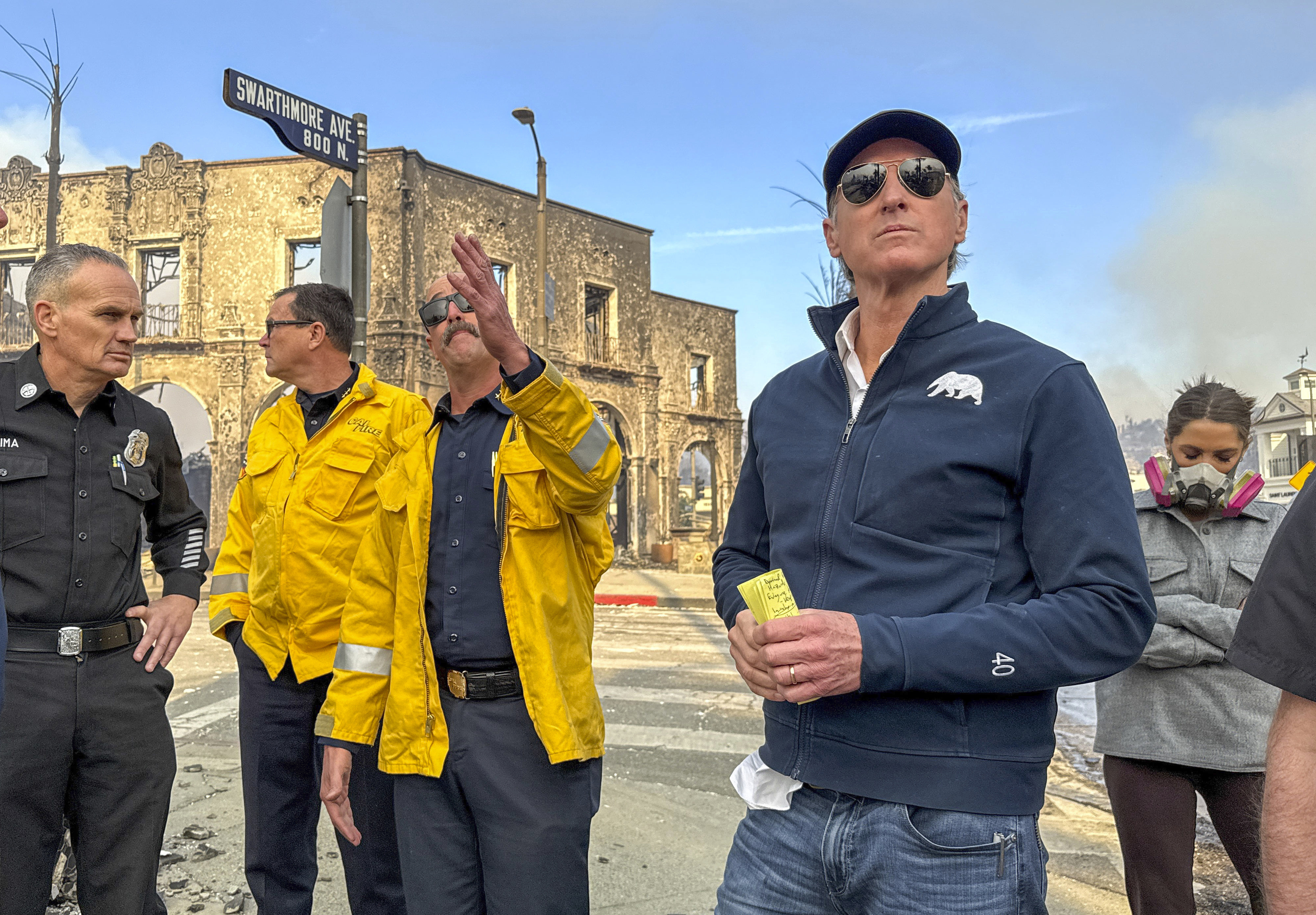 California Governor Gavin Newsom, right, surveys damage in Pacific Palisades with CalFire's Nick Schuler during the Palisades Fire on Wednesday, Jan. 8, 2025, in Pacific Palisades, Calif. (Jeff Gritchen/The Orange County Register via AP)