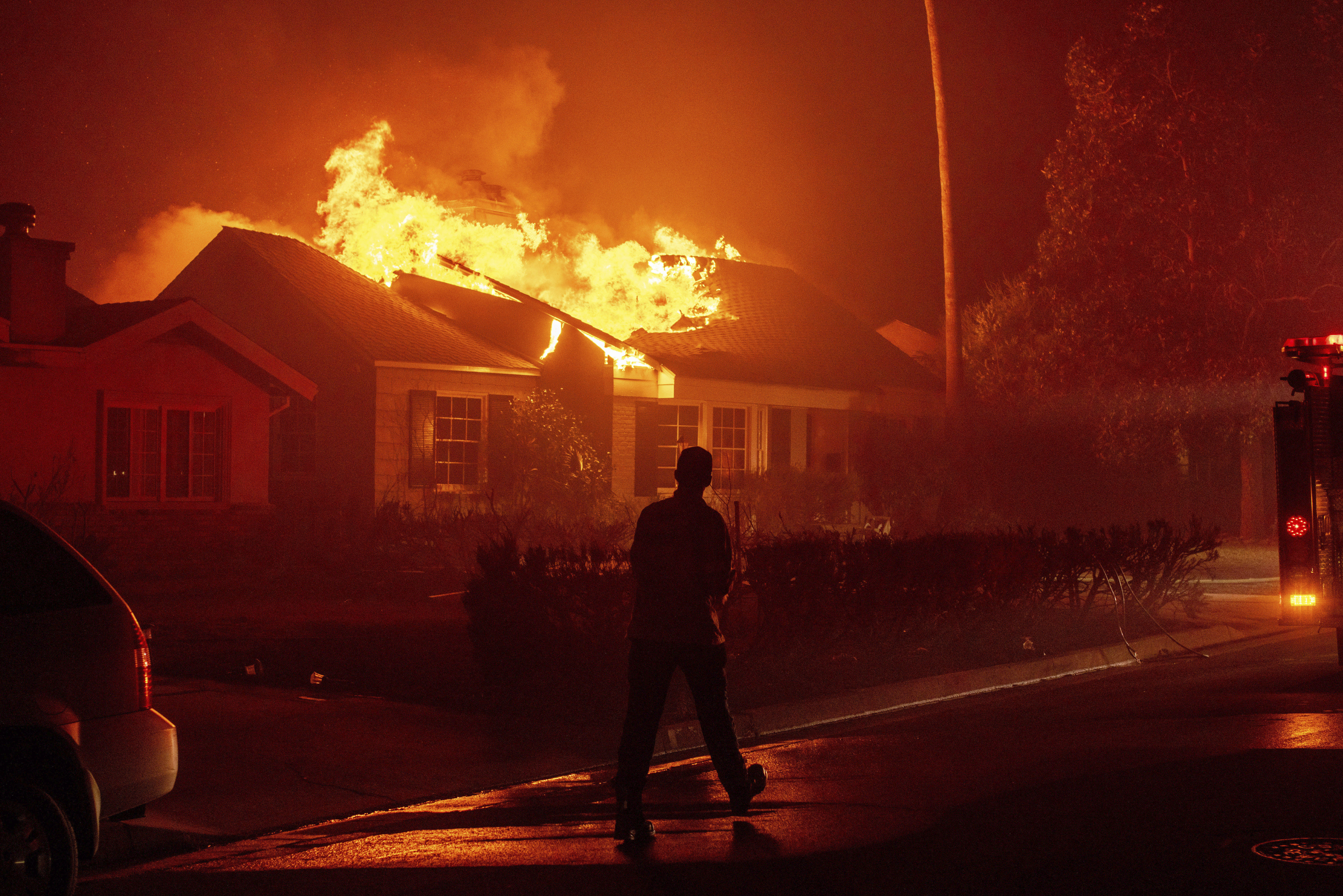 FILE - A firefighter walks toward a burning structure as the Eaton Fire advances Tuesday, Jan. 7, 2025 in Altadena, Calif. (AP Photo/Ethan Swope, File)