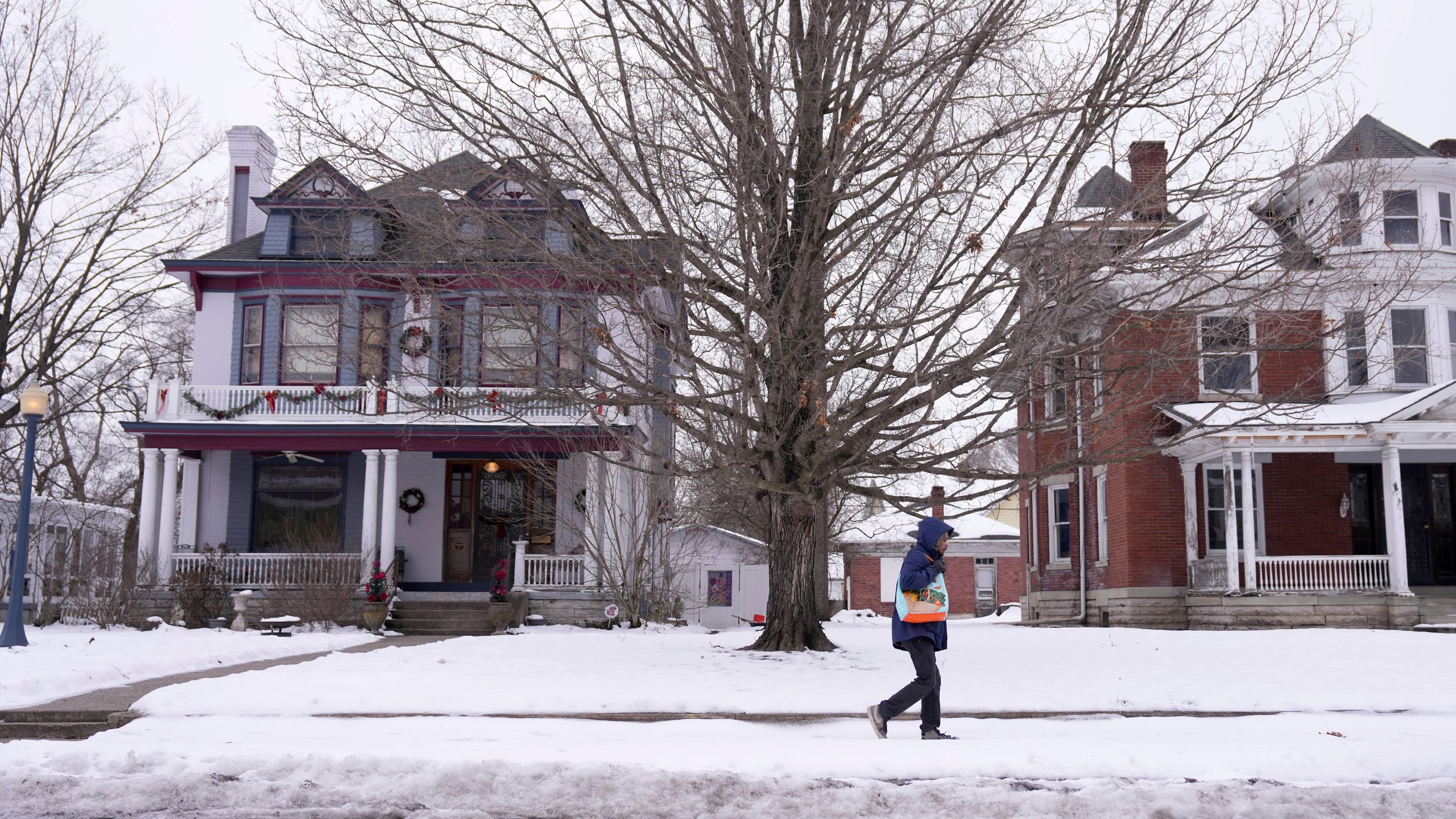 A Middletown resident walks through snow, Tuesday, Jan. 14, 2025, in Middletown, Ohio. The city is the hometown of Vice President-elect JD Vance.(AP Photo/Kareem Elgazzar)