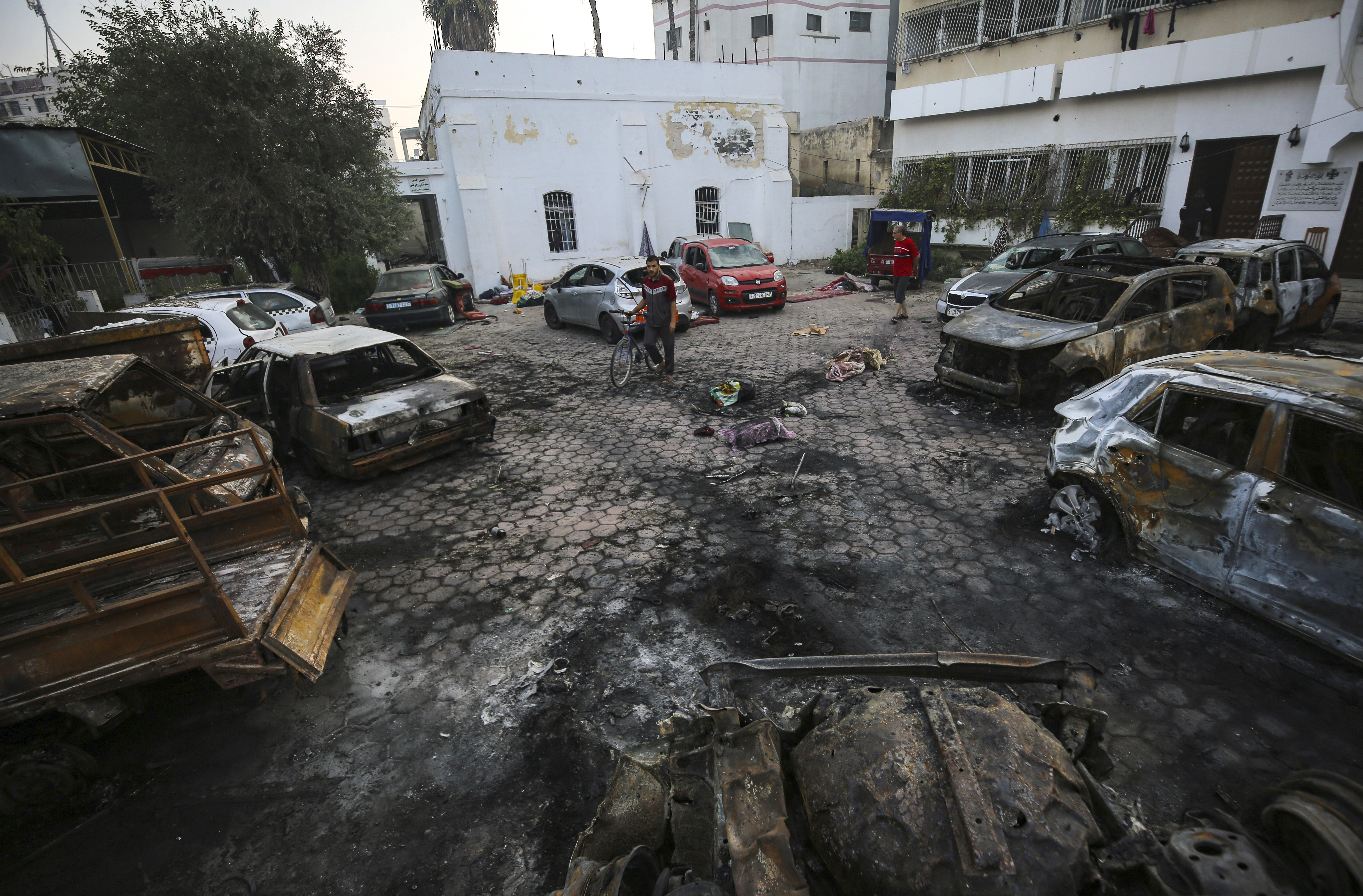 FILE - Men look over the site of a deadly explosion at Al-Ahli Hospital in Gaza City, on Oct. 18, 2023. (AP Photo/Abed Khaled, File)