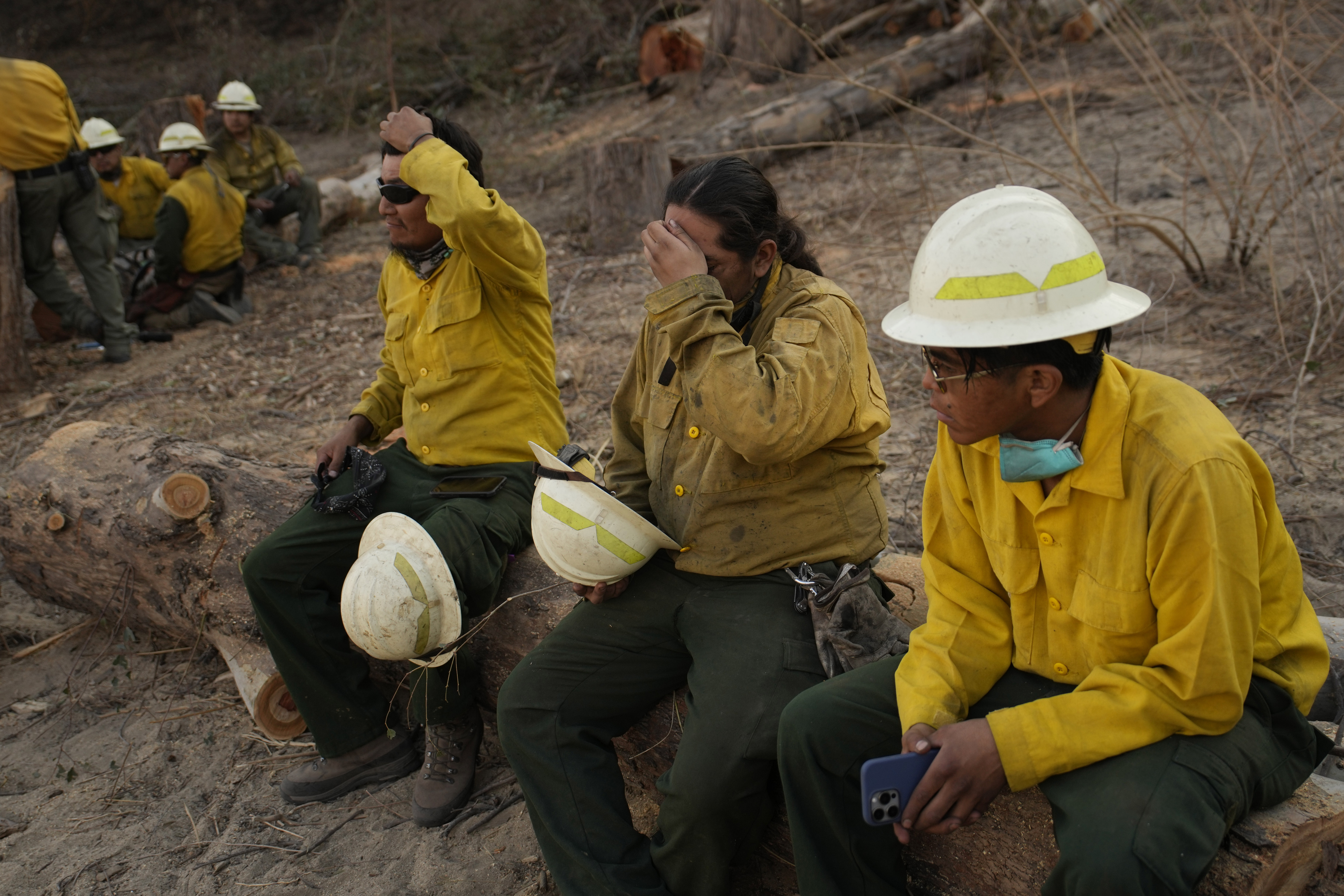 From left, Loren Tsosie, Deago Yanez, and Tyron Barber, of the Navajo Scouts firefighter crew, rest as they finish up working on the Eaton Fire, Friday, Jan. 17, 2025, in Pasadena, Calif. (AP Photo/John Locher)