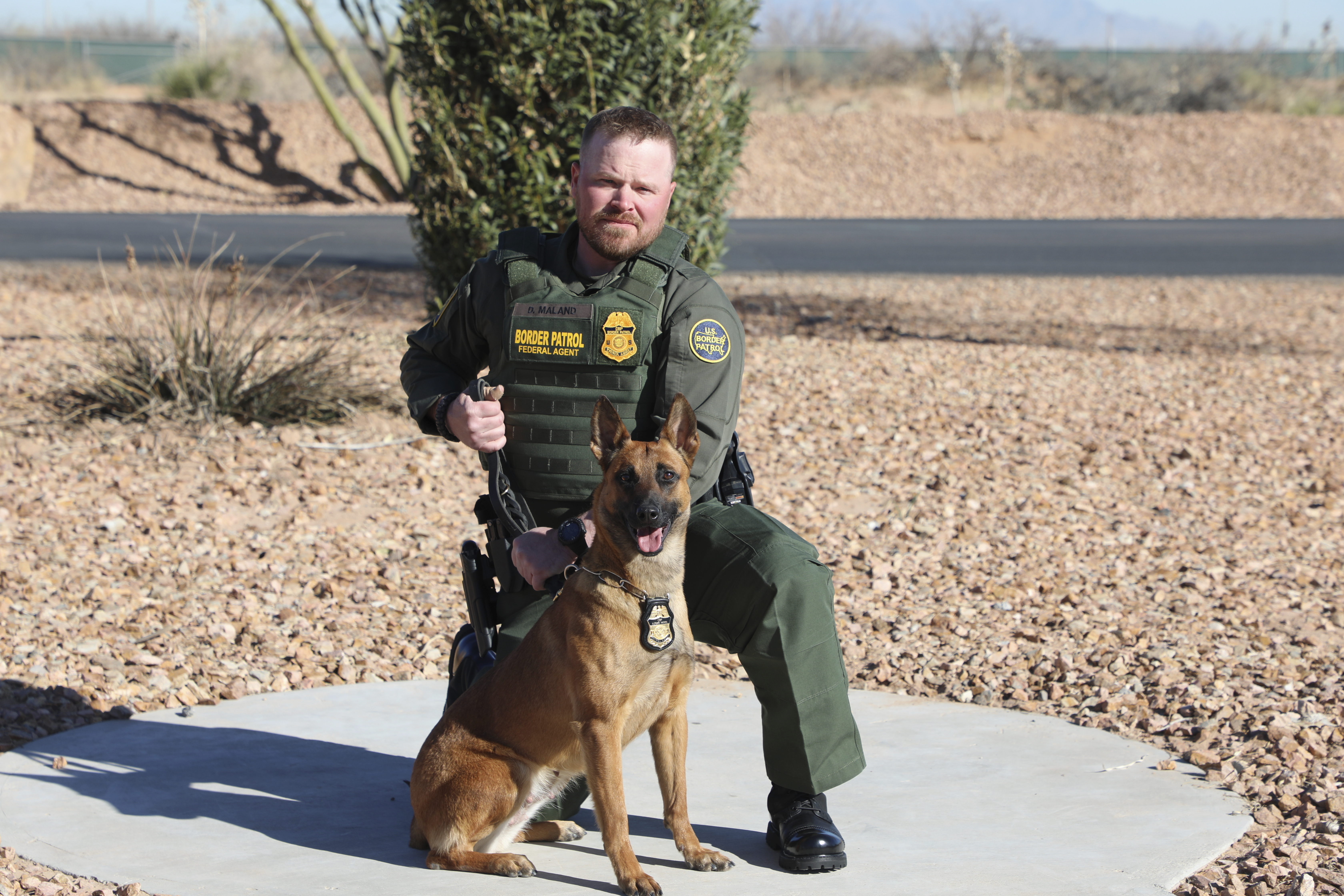 In this undated and unknown location photo released by the Department of Homeland Security shows Border Patrol Agent David Maland posing with a service dog. (Department of Homeland Security via AP)