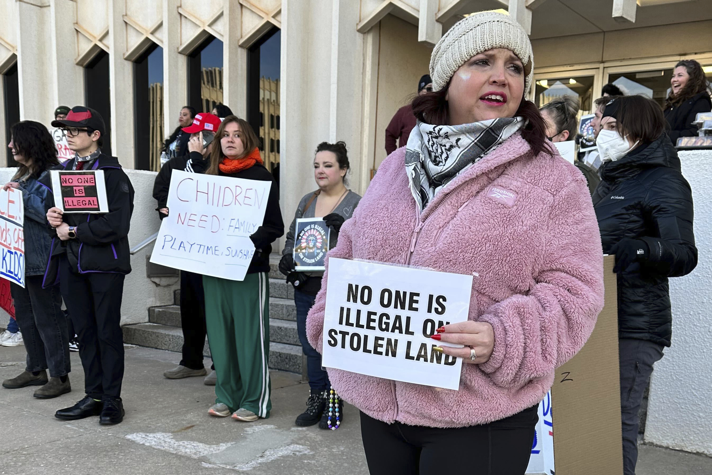 Erica Watkins of Tulsa, state director of Defense of Democracy holds a sign to protest Oklahoma's Board of Education considering a rule that would require parents enrolling children in public schools to provide proof of their child's U.S. citizenship or legal immigration status on Tuesday, Jan. 28, 2025 in Oklahoma City. (AP Photo/Sean Murphy)