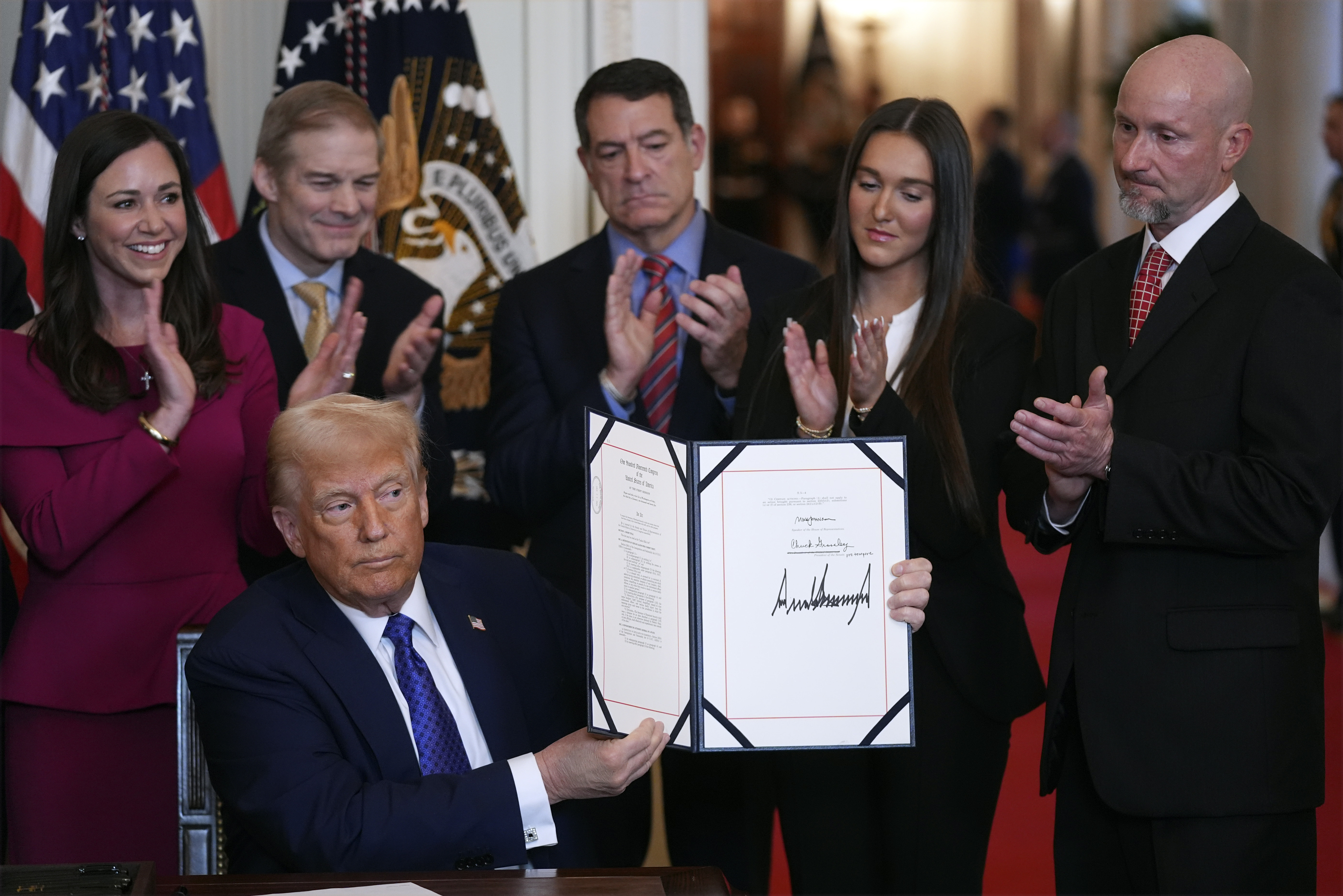 President Donald Trump holds the document after signing the Laken Riley Act during an event in the East Room of the White House, Wednesday, Jan. 29, 2025, in Washington. (AP Photo/Evan Vucci)