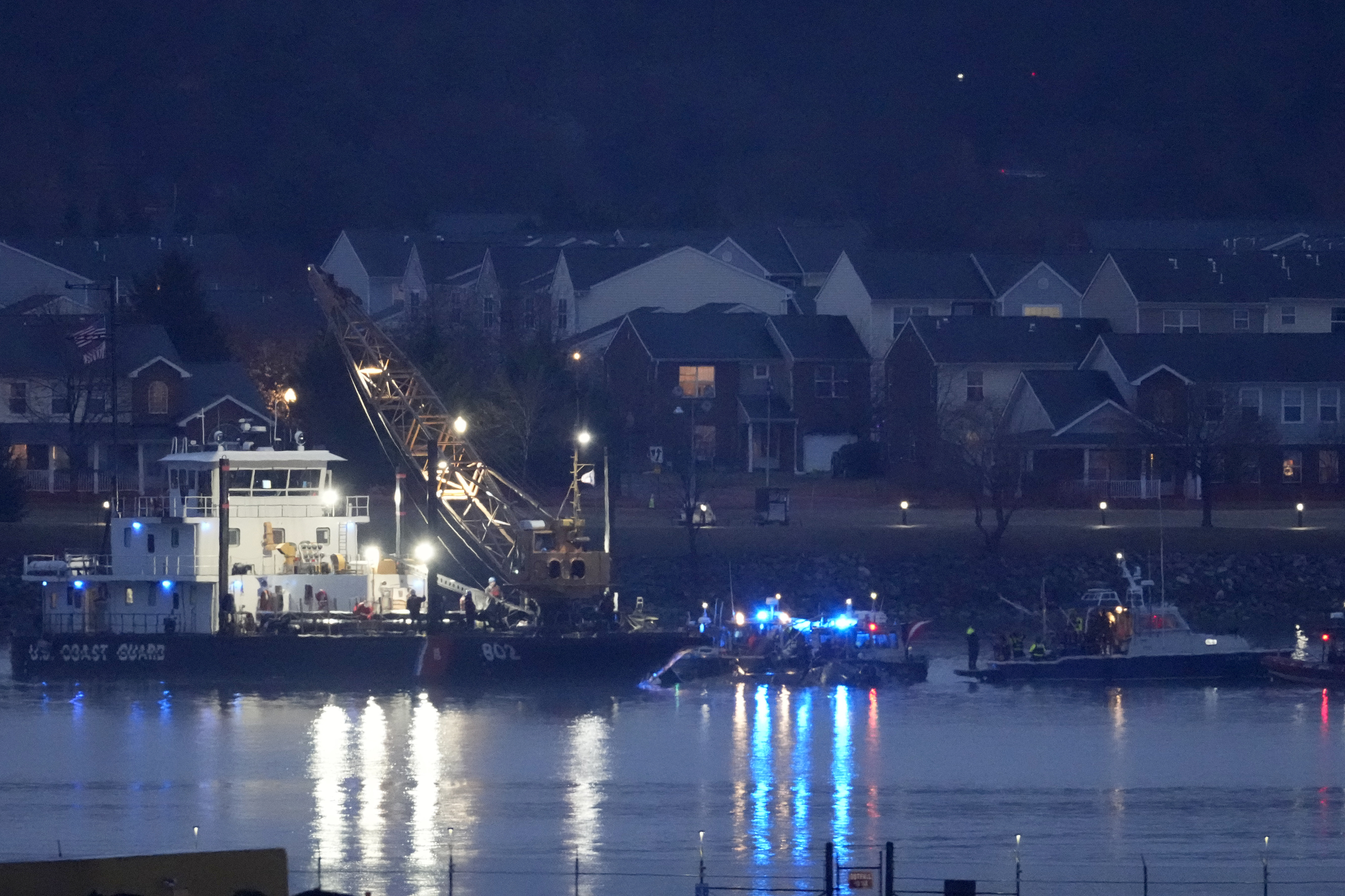 A Coast Guard vessel with a crane works near the wreckage of a Black Hawk helicopter in the Potomac River from Ronald Reagan Washington National Airport, Friday, Jan. 31, 2025, in Arlington, Va. (AP Photo/Alex Brandon)