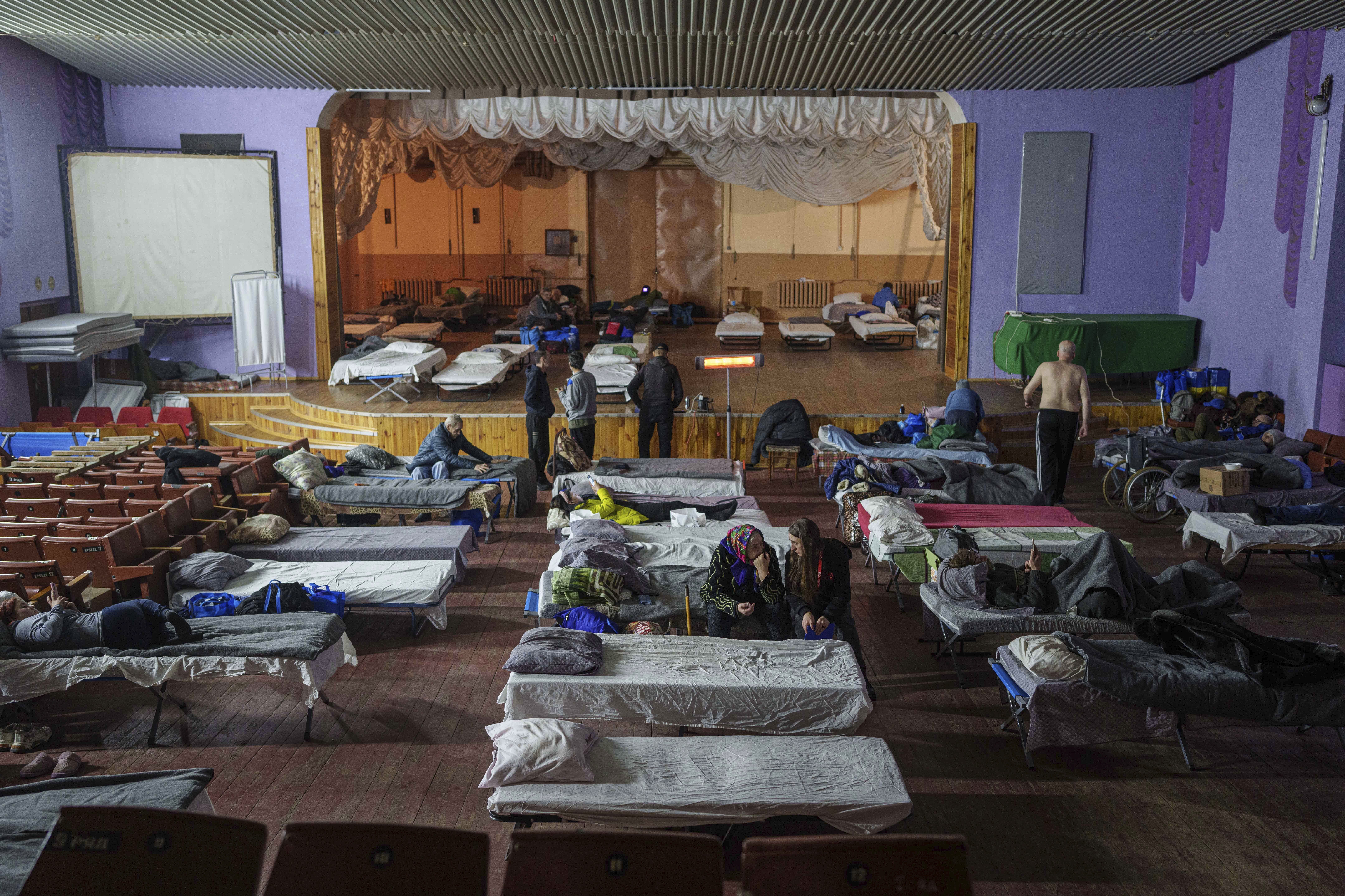 People sit on beds after evacuation from the frontline at a center for displaced people in Pavlohrad, Ukraine, Saturday, Feb. 1, 2024. (AP Photo/Evgeniy Maloletka)Maloletka)