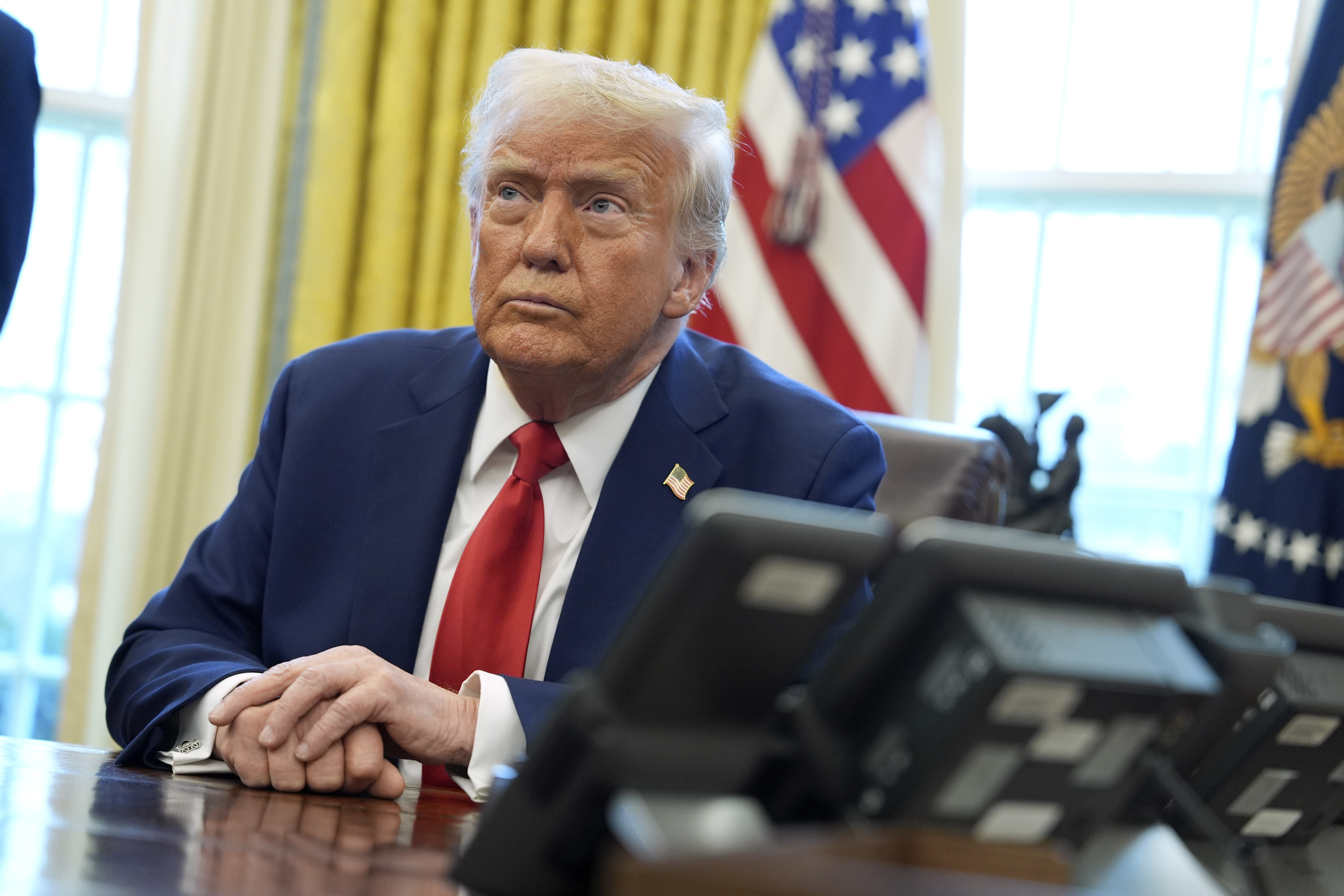 President Donald Trump listens after signing executive orders in the Oval Office of the White House, Monday, Feb. 3, 2025, in Washington. (AP Photo/Evan Vucci)