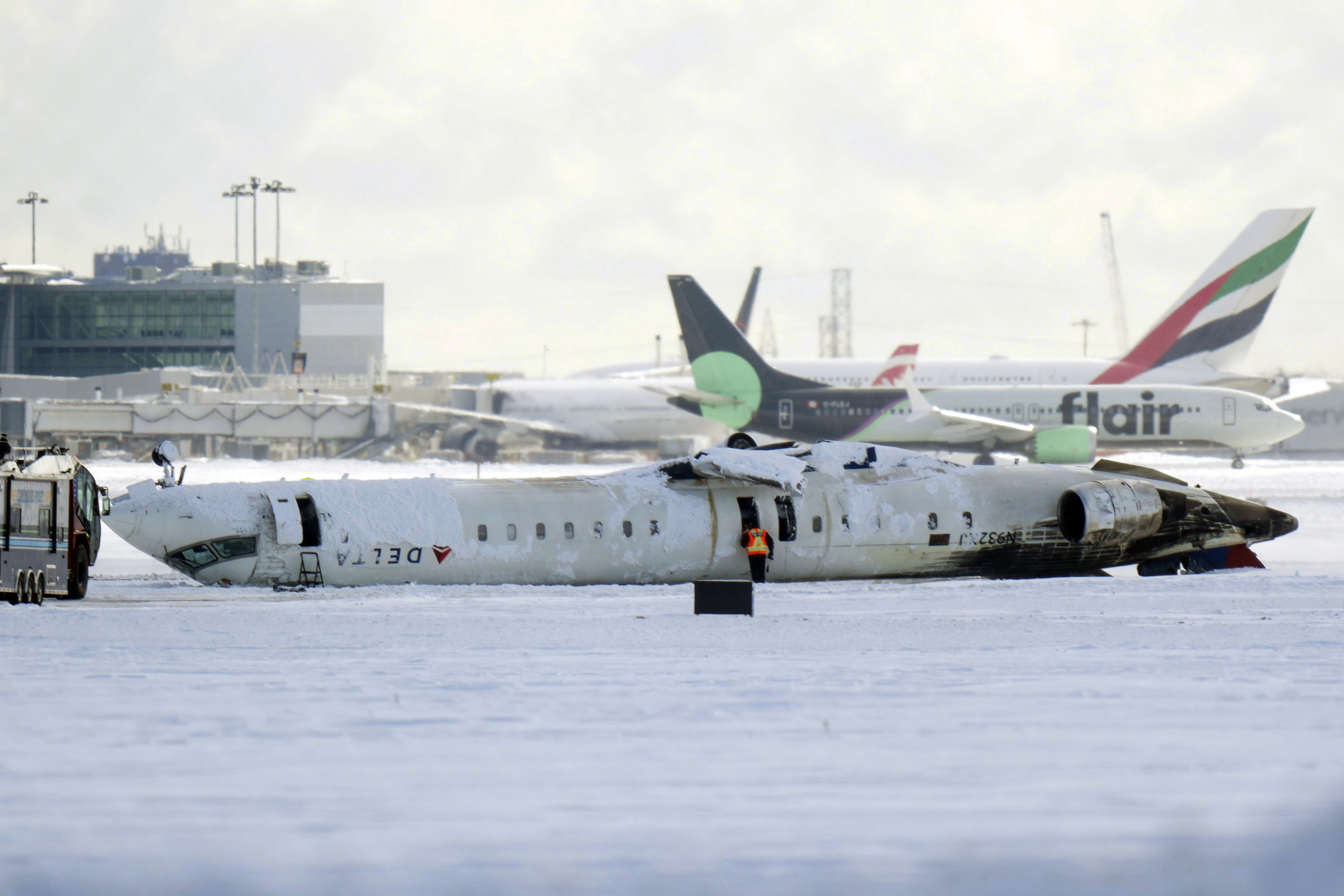 A Delta Air Lines plane lies upside down at Toronto Pearson Airport on Tuesday, Feb. 18, 2025. (Chris Young/The Canadian Press via AP)