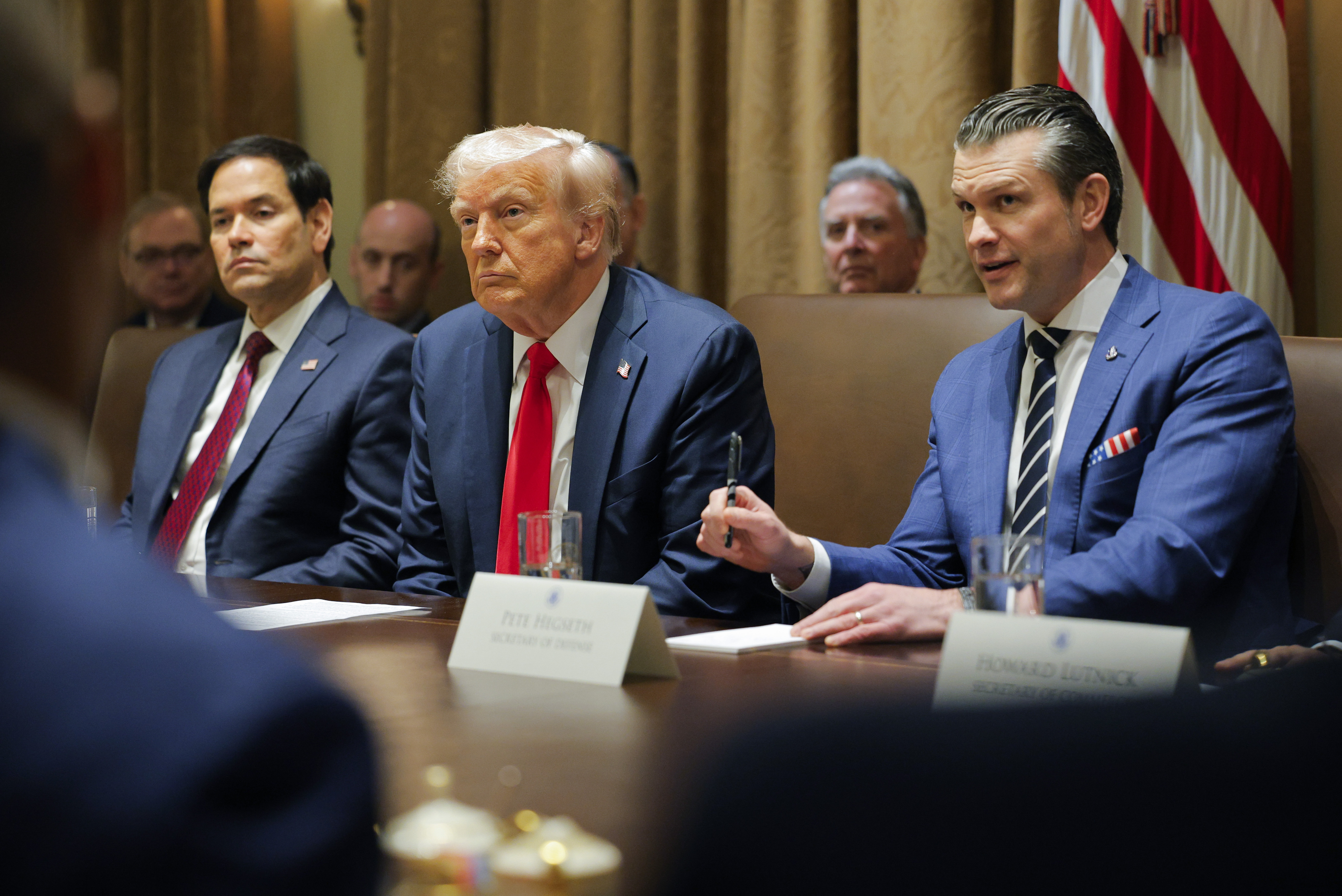 President Donald Trump listens during a Cabinet meeting at the White House in Washington, Wednesday, Feb. 26, 2025, as Secretary of State Marco Rubio and Defense Secretary Pete Hegseth listen. (Pool via AP)