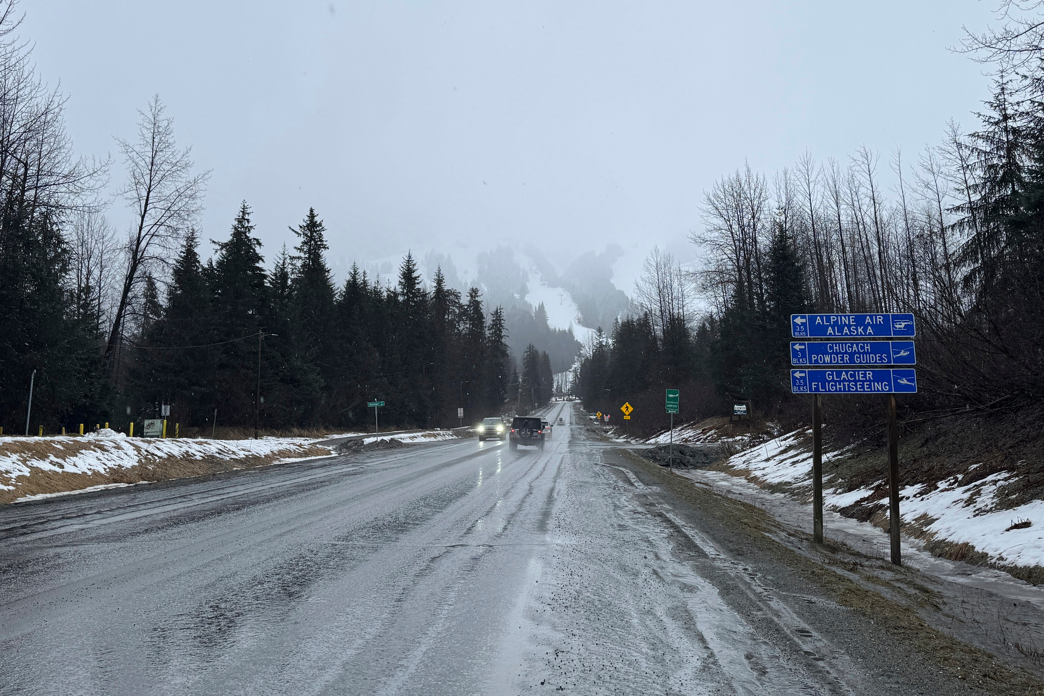 A sign on Alyeska Highway points to winter tourism businesses in Girdwood, Alaska, on Wednesday, March 1, 2025. (AP Photo/Mark Thiessen)