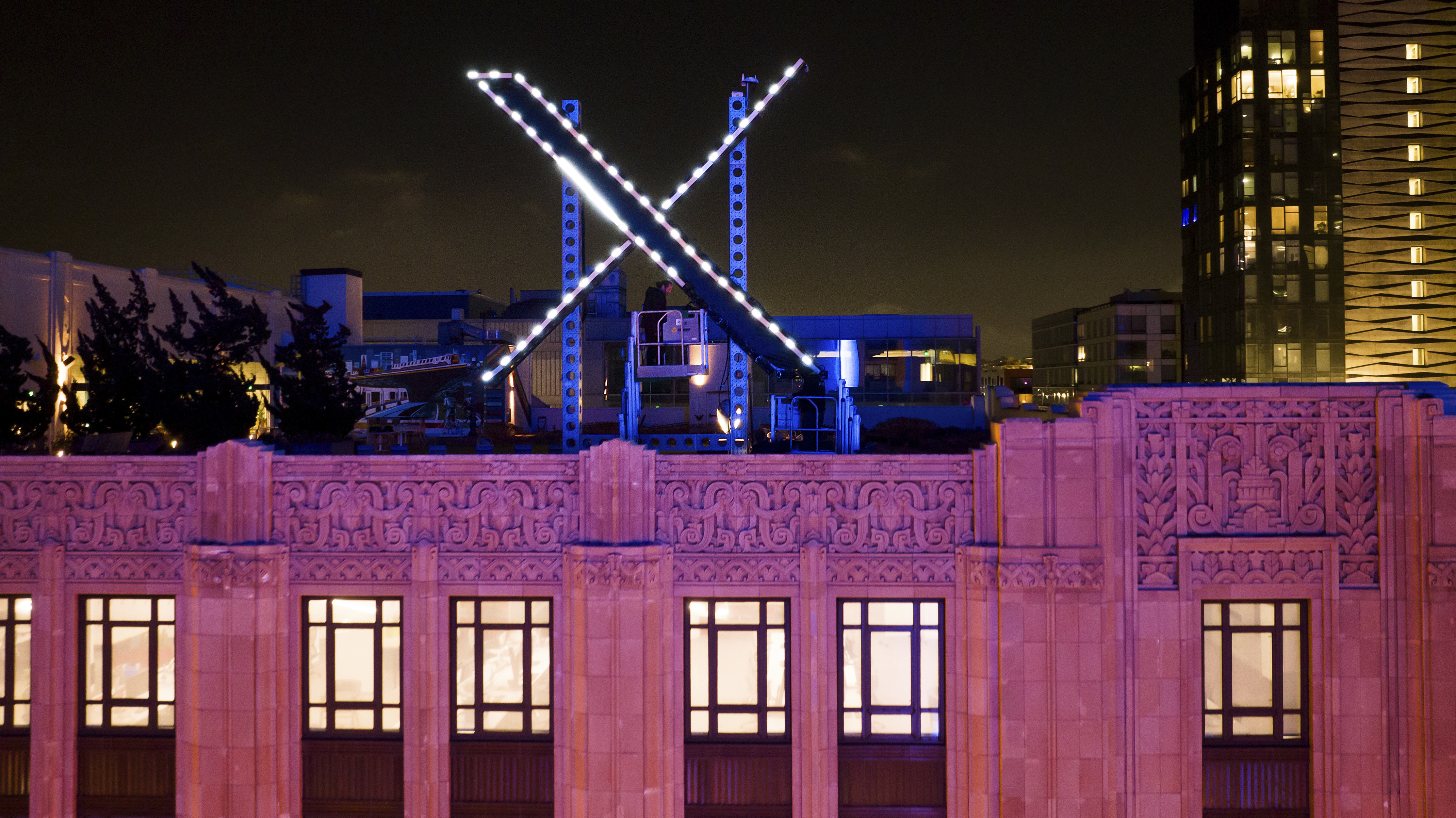 FILE - Workers install lighting on an "X" sign atop the company headquarters, formerly known as Twitter, in downtown San Francisco, on Friday, July 28, 2023. (AP Photo/Noah Berger, File)