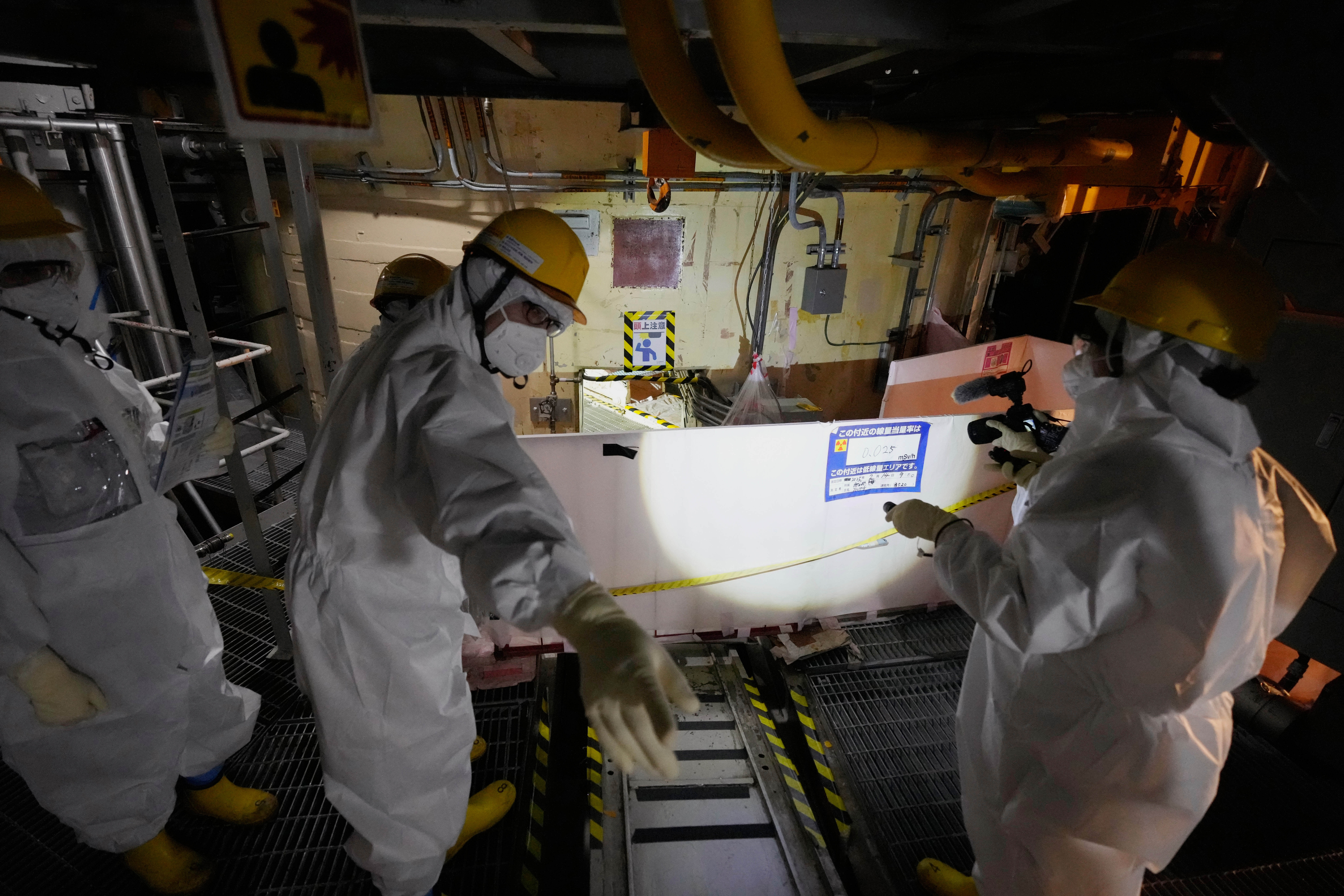 Employees of Tokyo Electric Power Company Holdings (TEPCO) take AP journalists to the area under the Unit 5 reactor pressure vessel, which survived the earthquake-triggered tsunami in 2011, at the Fukushima Daiichi nuclear power plant in Futaba town, northeastern Japan, on Monday Feb. 20, 2025. (AP Photo/Eugene Hoshiko)